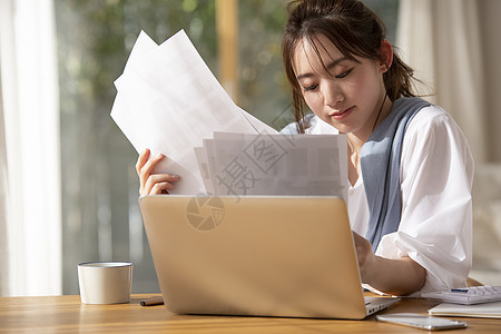 看着文件资料的职业女性图片