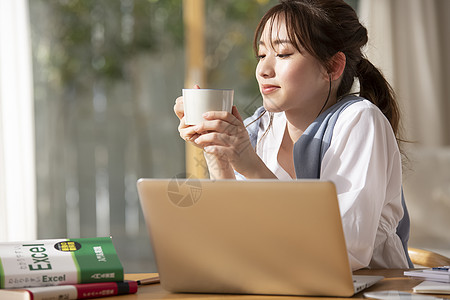 居家办公喝咖啡的年轻女子高清图片