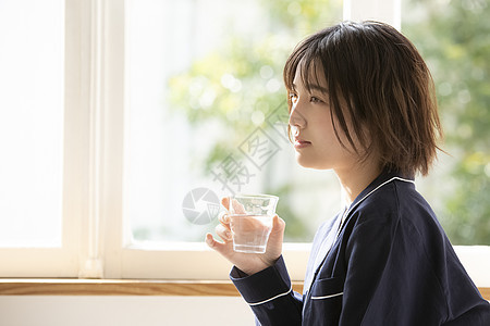 居家拿着水杯的年轻女子图片