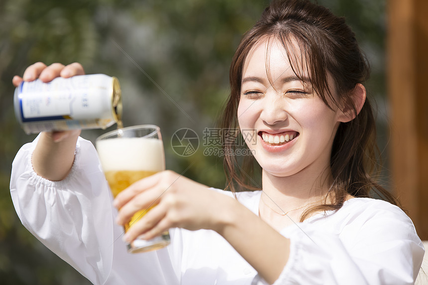 倒啤酒开心的年轻女子图片