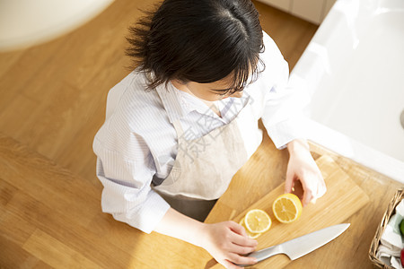 厨房切柠檬的年轻女子图片