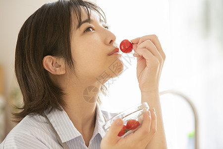 吃小番茄的年轻女子图片