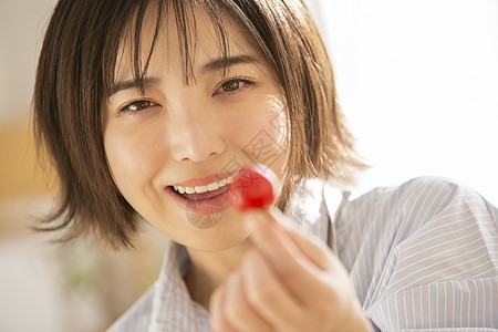 拿着蕃茄微笑的年轻女子图片