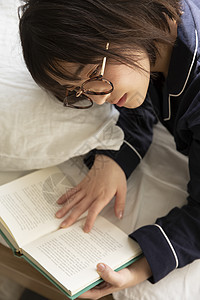 年轻女子戴着眼镜看书图片