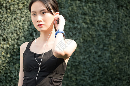 户外运动戴着耳机的女青年图片