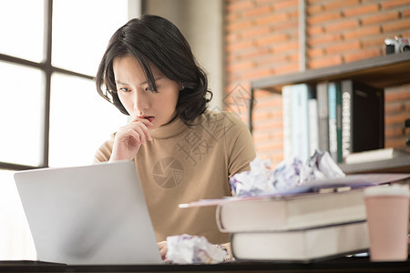 看着笔记本电脑苦恼的职业女性图片