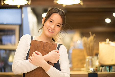 抱着托盘微笑的咖啡馆女店员图片