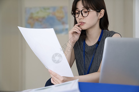 拿着文件思考的青年女子图片