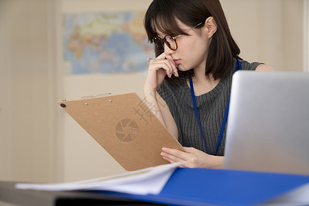 拿着文件思考的青年女子图片