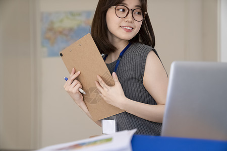 办公室拿着文件微笑的青年女子图片