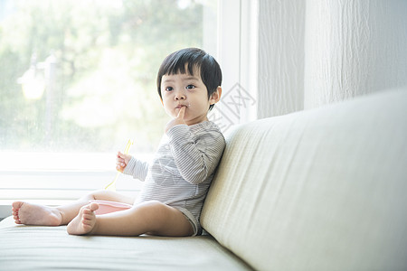 给婴儿擦嘴居家的可爱小朋友和年轻妈妈背景