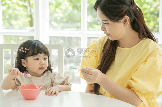 照顾女儿喂饭的母亲图片