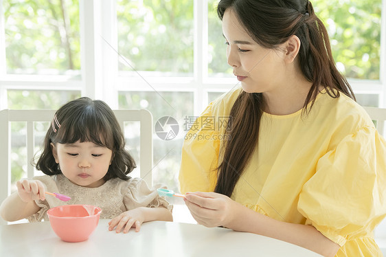 照顾女儿喂饭的母亲图片