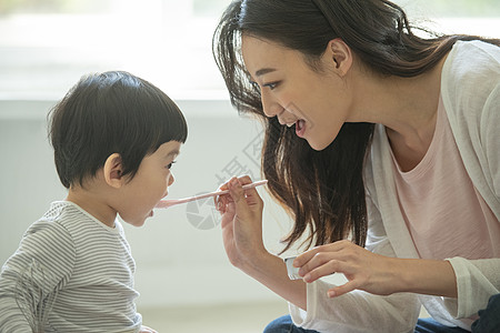 妈妈陪小朋友在客厅地毯上吃饭图片