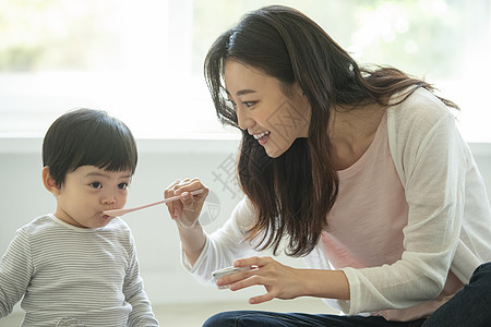 妈妈陪小朋友在客厅地毯上吃饭图片