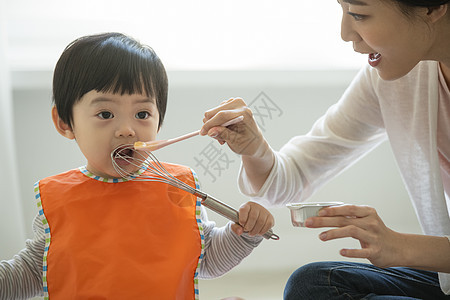 妈妈陪小朋友在客厅地毯上吃饭图片