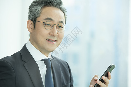 拿着手机微笑的商务男性图片