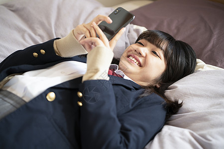 检查生活资料高中女生学生躺在床上看智能手机图片