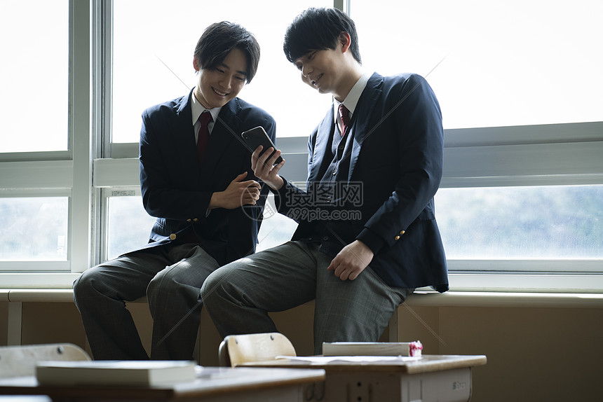在窗户旁享受男生学生在教室里与朋友共度时光图片