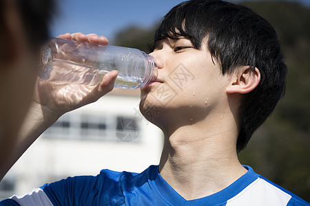 夏胸像高中生男子在运动中喝水图片