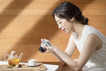 拿着相机拍照的青年女子图片