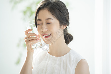 拿着水杯微笑的青年女子背景图片