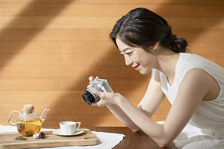 青年女子拿着相机拍照图片