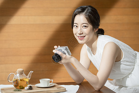 茶馆拿着相机拍照的青年女子图片
