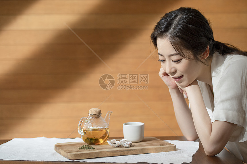 看着茶具的青年女子图片