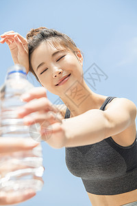 接过水微笑的运动女青年图片