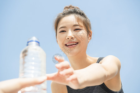 接过水微笑的运动女青年图片