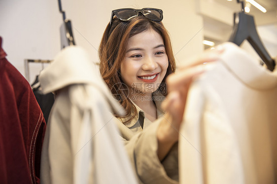 服装店挑选衣服的年轻女子图片