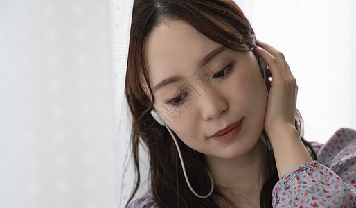 年轻女子戴着耳机听音乐图片