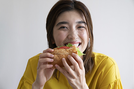 寿司料理吃三明治的年轻女子背景