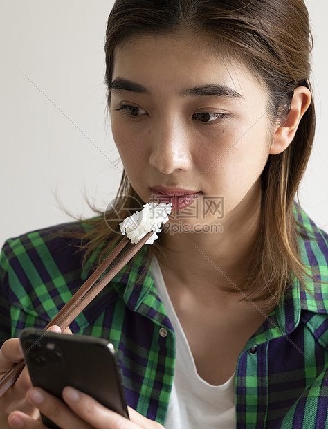 吃饭看手机的年轻女子图片