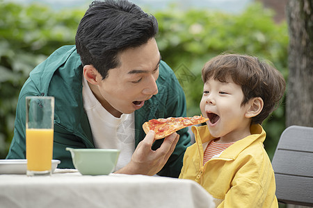 户外野餐喂孩子吃披萨的父亲图片