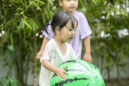 户外庭院抱着球的小女孩图片