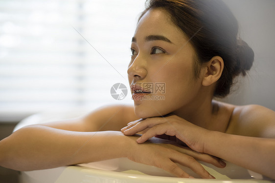 浴缸里泡澡放松的年轻女子图片