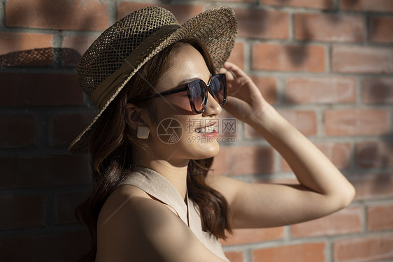 夏日戴着草帽和墨镜的年轻女子图片