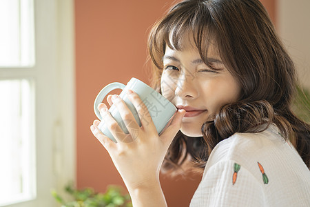 年轻女子捧着咖啡微笑图片