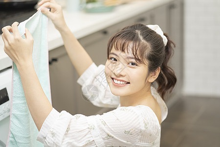 折叠毛巾微笑的年轻女子图片