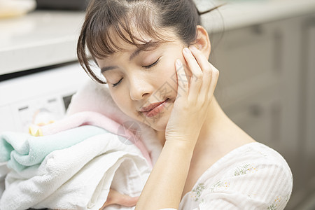 年轻女子抱着毛巾微笑图片