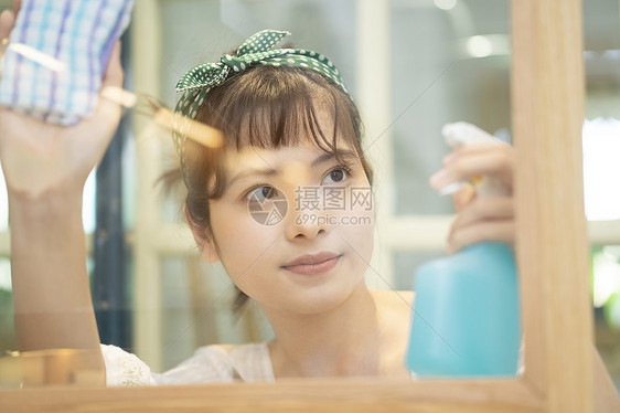 居家做家务清洁窗户玻璃的年轻女子图片