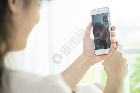 年轻女子拿着手机视频通话图片