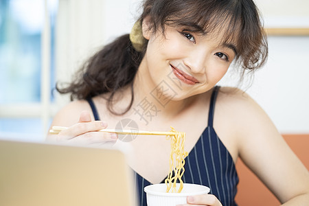 在家边工作边吃泡面的居家女孩图片