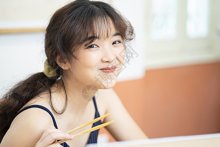 在家边工作边吃泡面的居家女孩图片