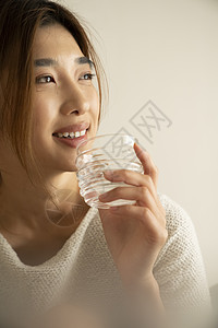拿着水杯喝水的年轻女子图片
