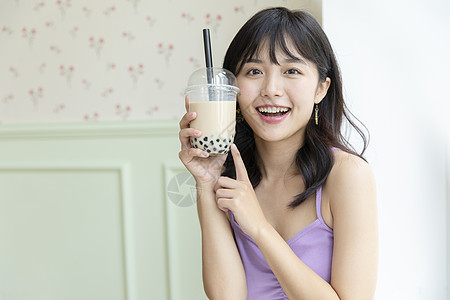 黄玉珍珠花簪拿着奶茶微笑的青春可爱少女背景