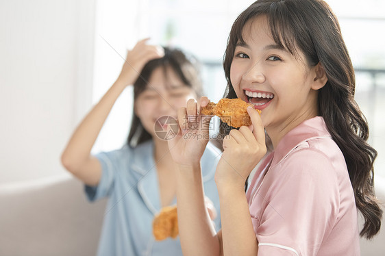 吃炸鸡开心的年轻女子图片