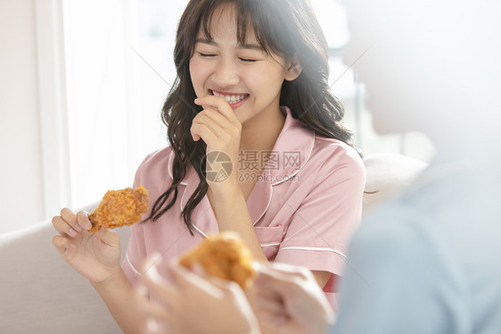 拿着炸鸡开心的年轻女子图片